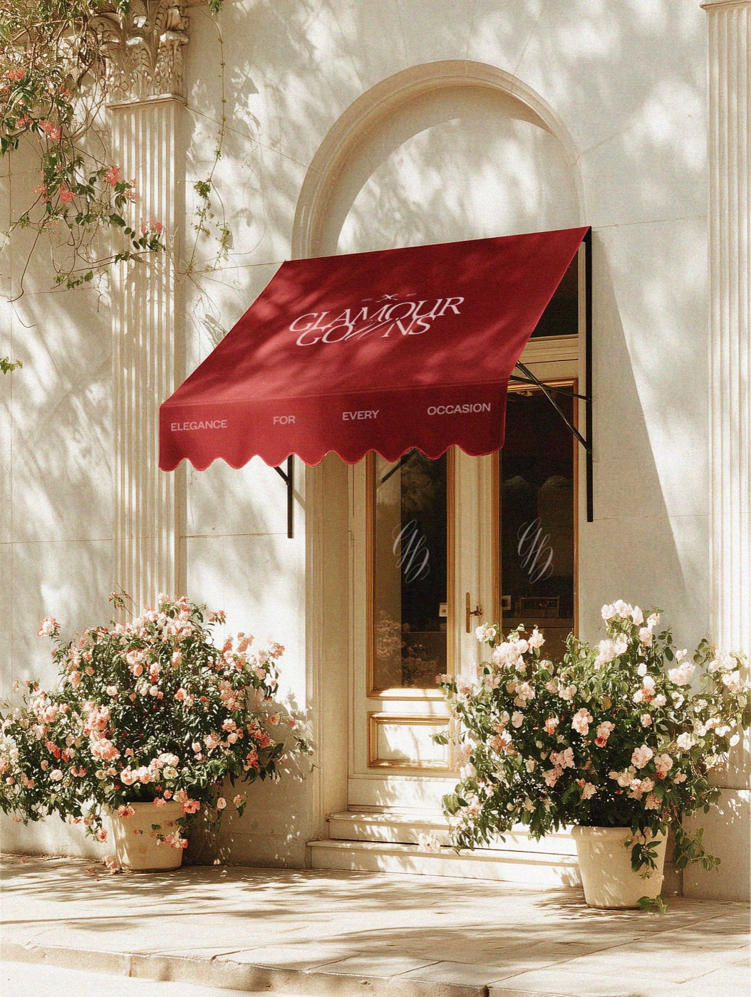 A boutique entrance with a burgundy Glamour Gowns awning and flowers